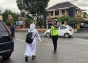 Polsek Rasanae Barat Laksanakan Rawan Pagi, Bantu Pelajar Menyeberang Jalan